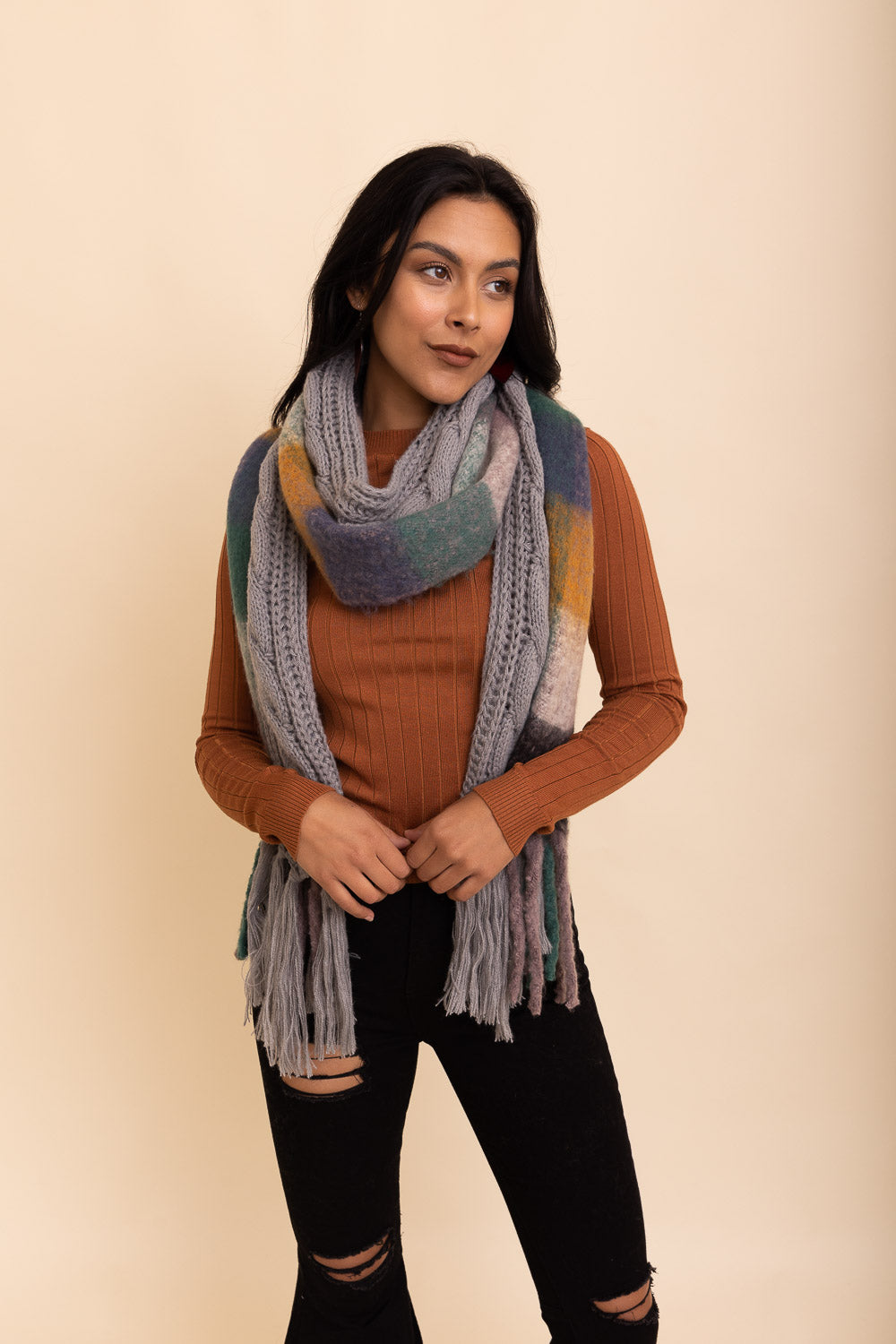 A stylish knit blend scarf with tassel trim, perfect for cold weather outfits, showcasing its soft texture and trendy design.