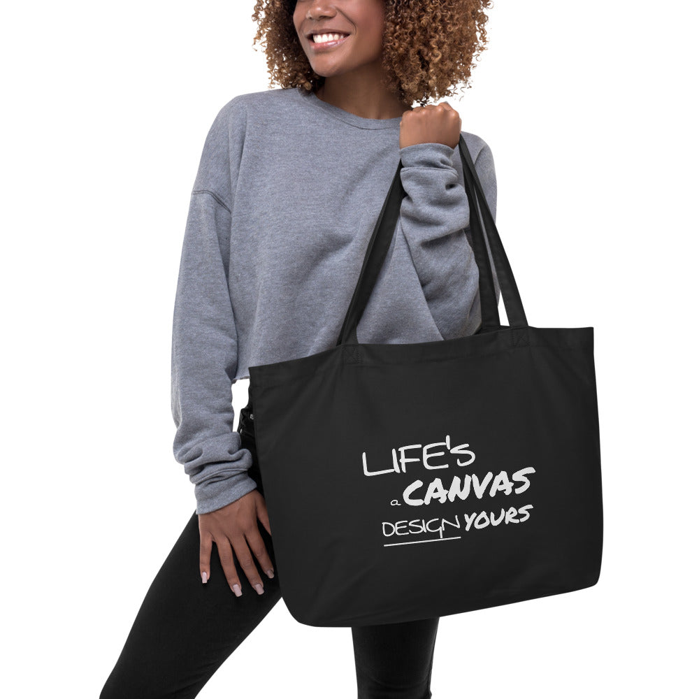 Large black tote bag with inspirational print, featuring durable cotton material and long dual straps for easy carrying.