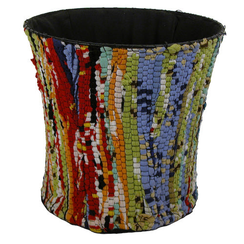 A large, colorful wastebasket made from recycled cloth scraps, showcasing unique patterns and vibrant colors, perfect for eco-friendly waste separation.