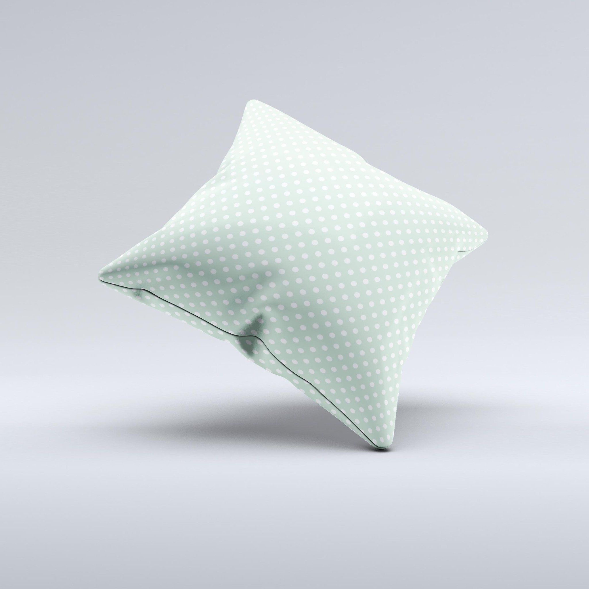 Light green decorative throw pillow with white polkadots, showcasing a unique handcrafted design.