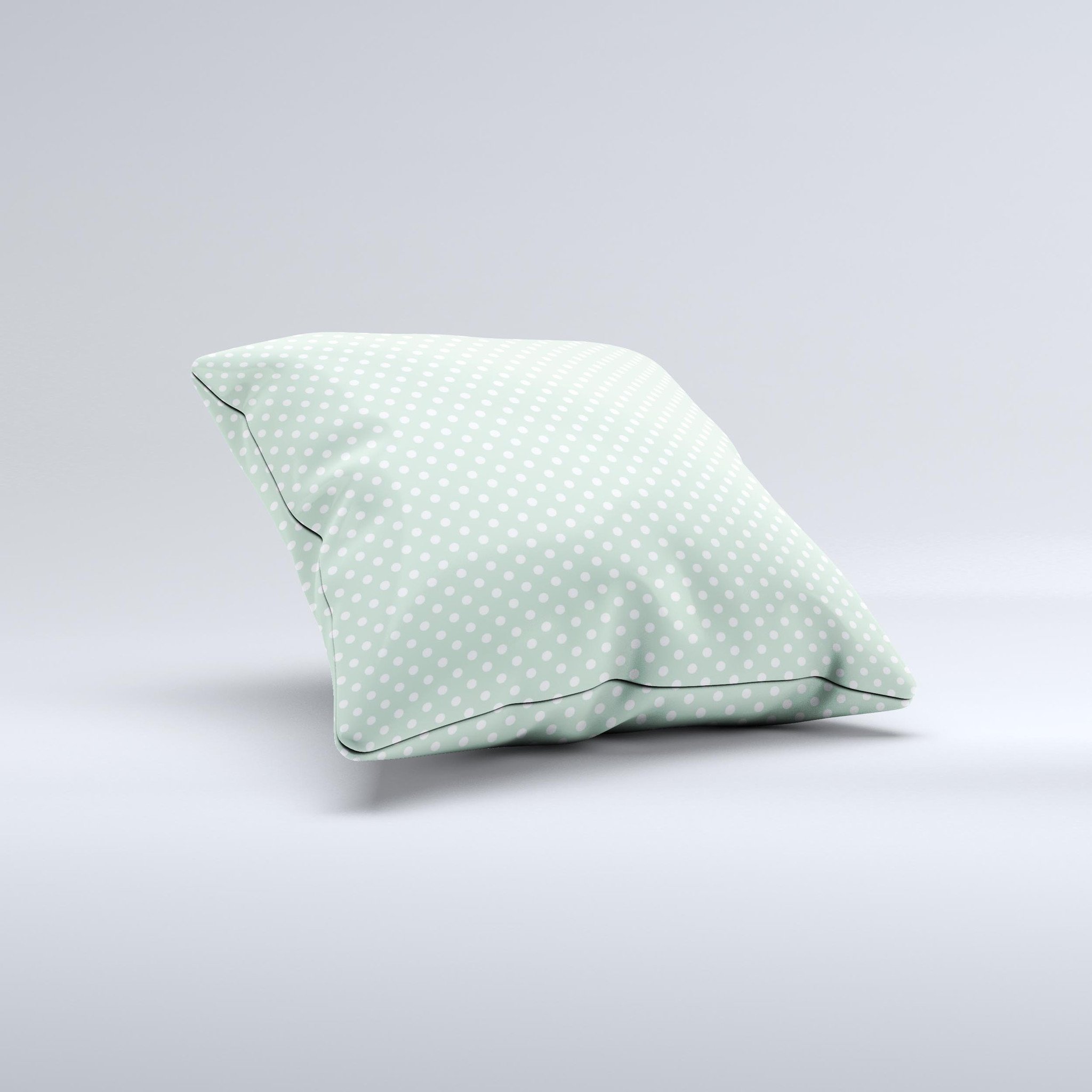 Light green decorative throw pillow with white polkadots, showcasing a unique handcrafted design.