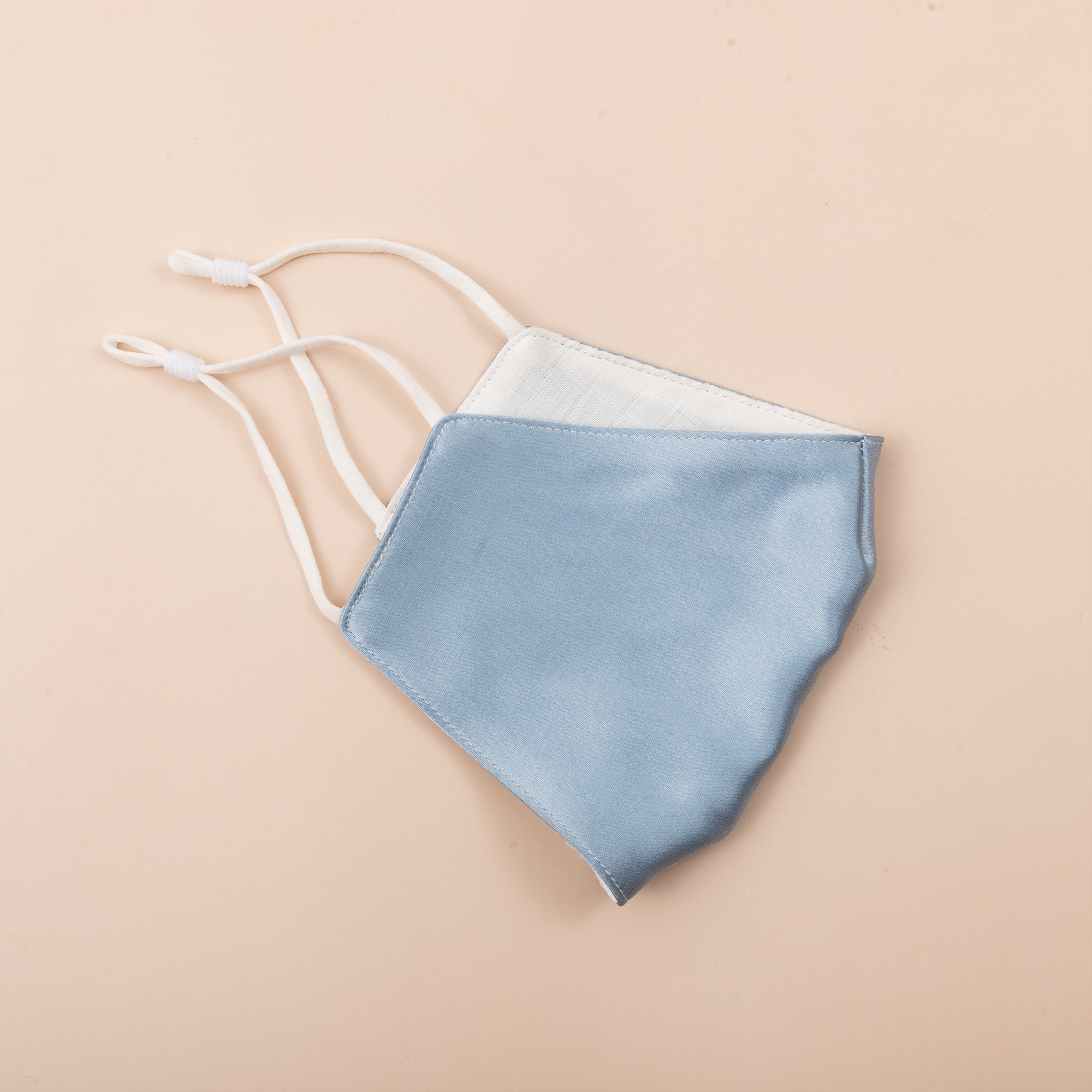 Lily Satin Face Mask featuring adjustable ear loops, soft satin exterior, and a filter pocket for added protection.