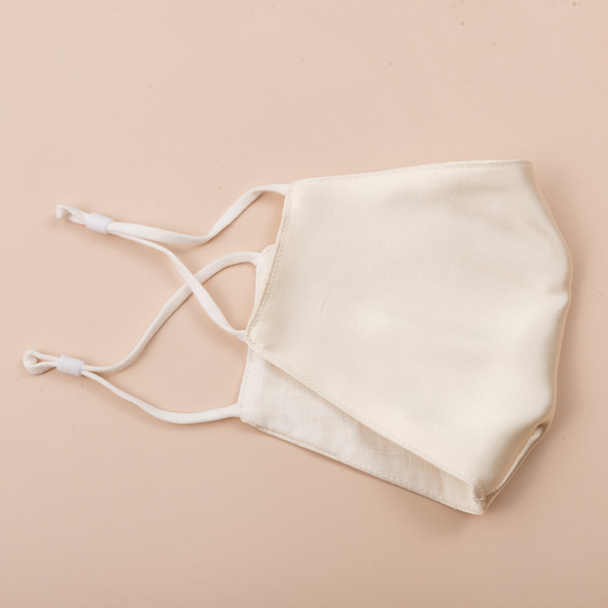 Lily Satin Face Mask featuring adjustable ear loops, soft satin exterior, and a filter pocket for added protection.