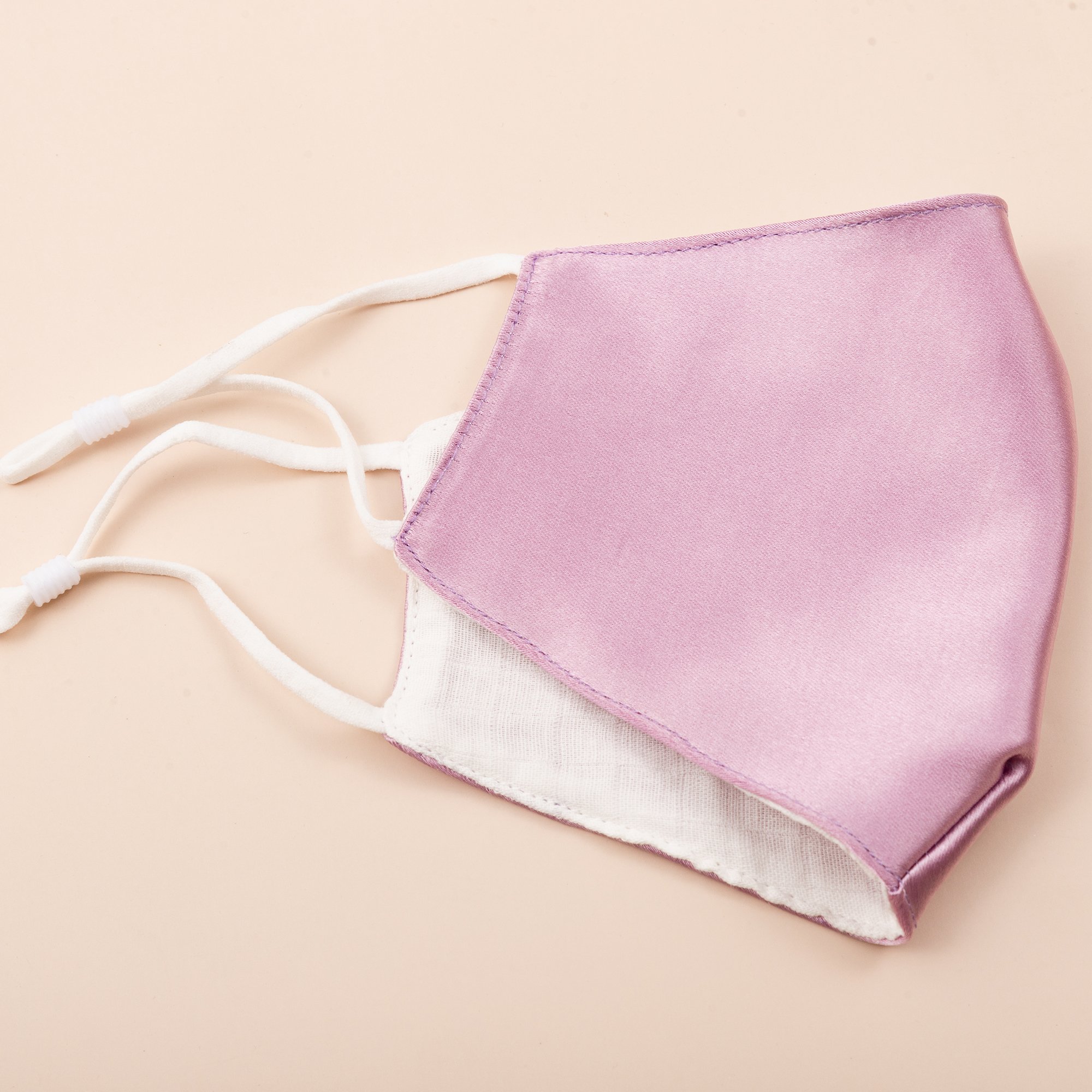 Lily Satin Face Mask featuring adjustable ear loops, soft satin exterior, and a filter pocket for added protection.