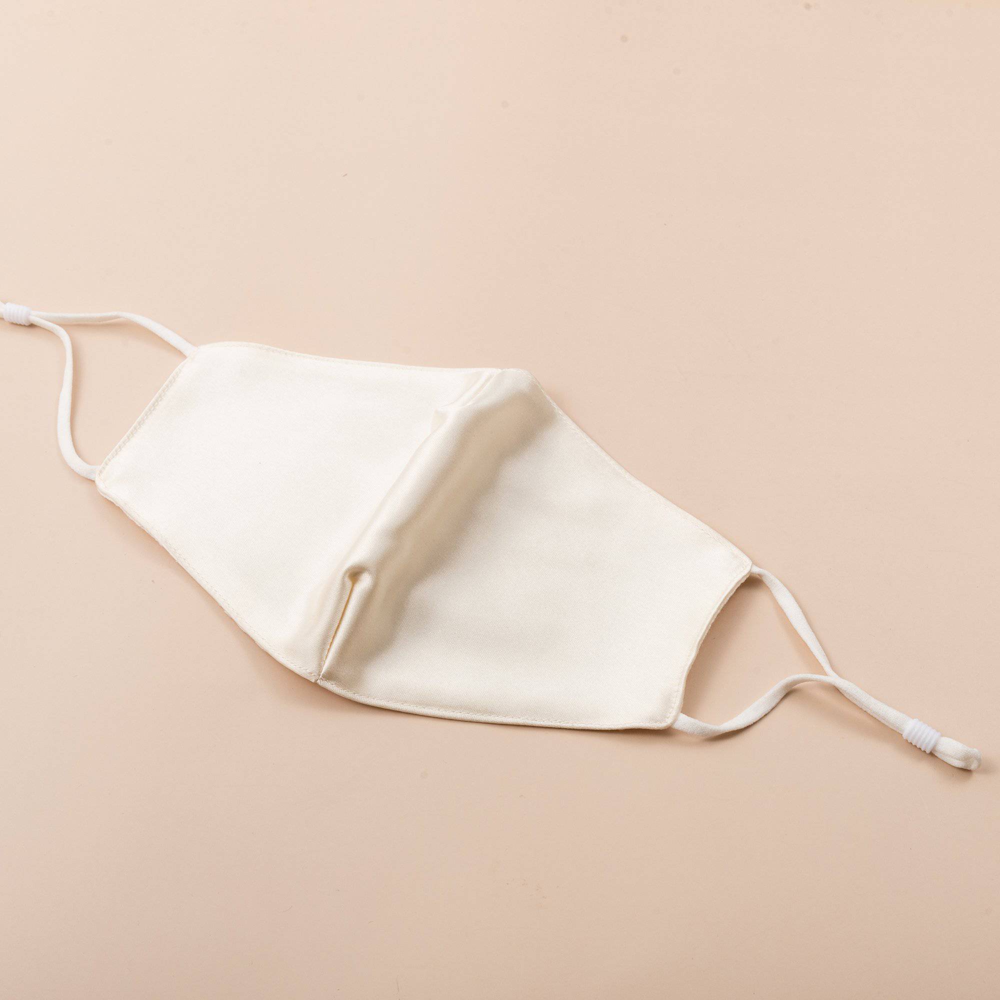 Lily Satin Face Mask featuring adjustable ear loops, soft satin exterior, and a filter pocket for added protection.