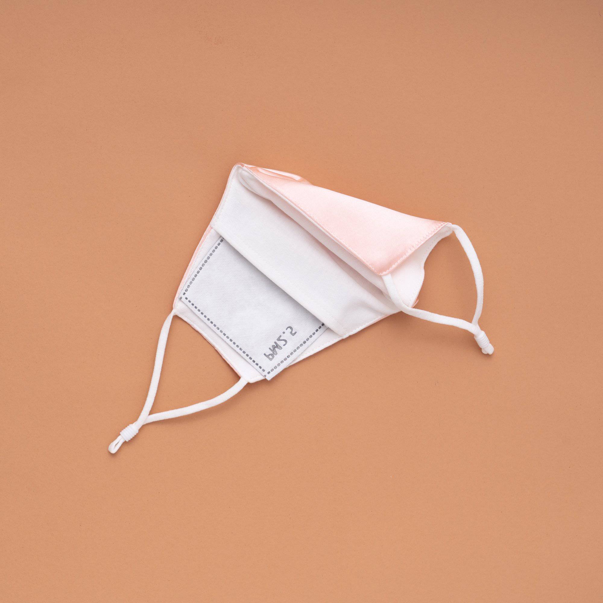 Lily Satin Face Mask featuring adjustable ear loops, soft satin exterior, and a filter pocket for added protection.