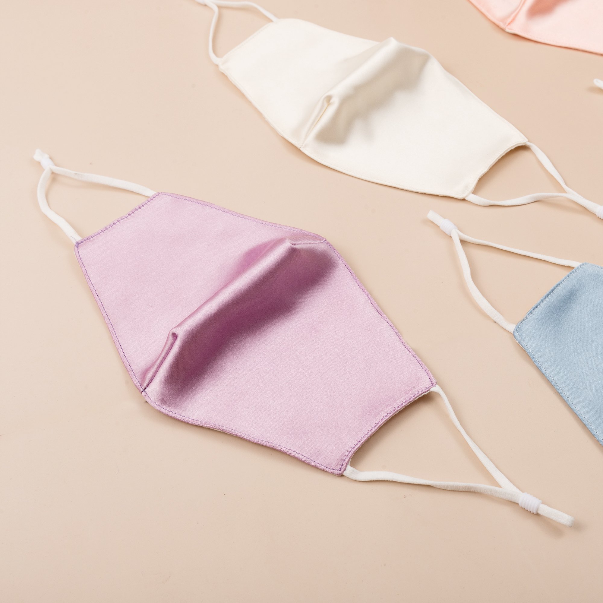 Lily Satin Face Mask featuring adjustable ear loops, soft satin exterior, and a filter pocket for added protection.