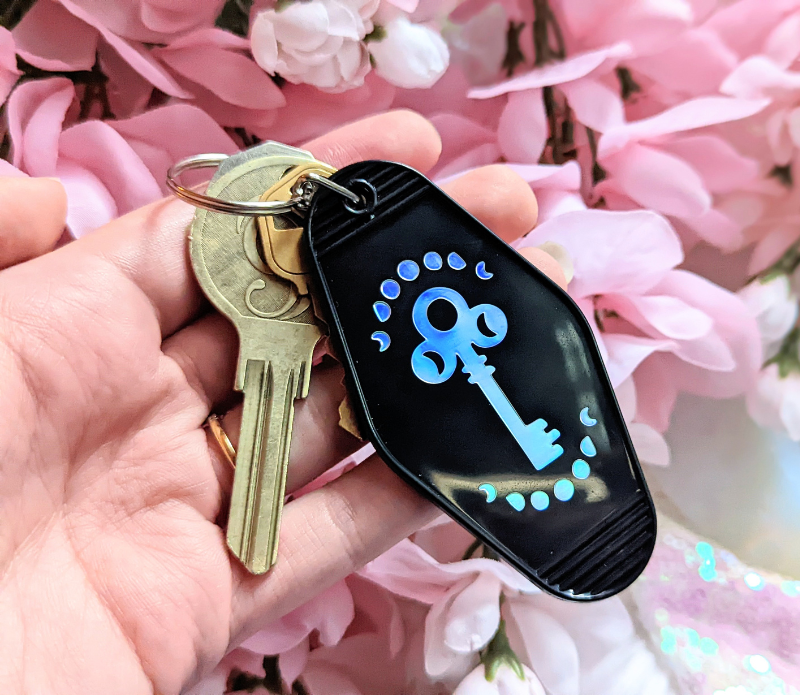 A vibrant Luminous Light Keychain featuring a retro design with the mantra 'Love is the Key', made from recycled plastic.