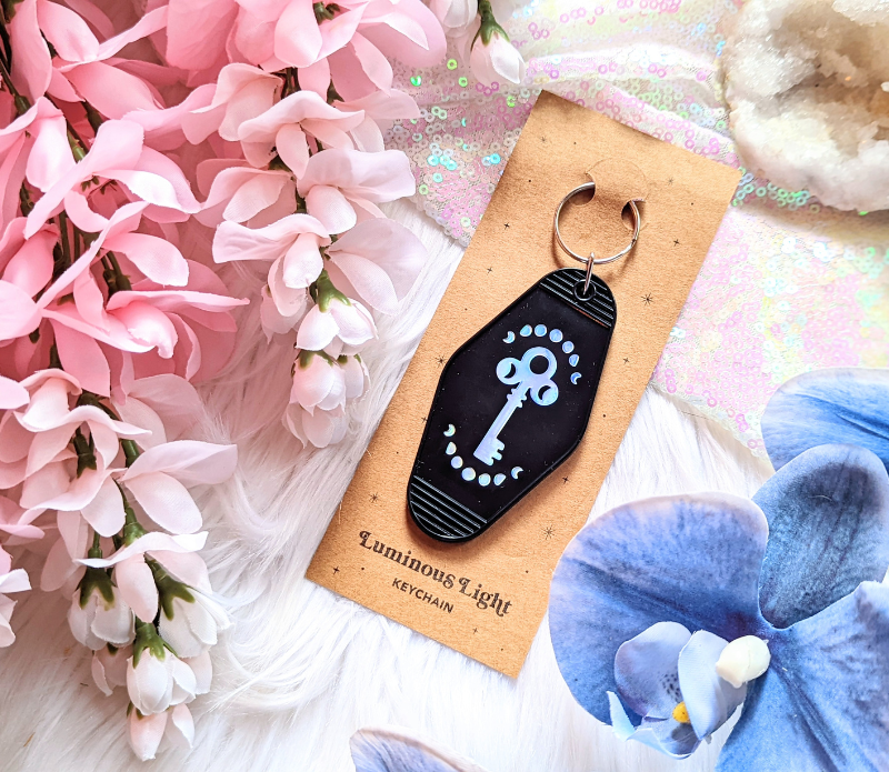 A vibrant Luminous Light Keychain featuring a retro design with the mantra 'Love is the Key', made from recycled plastic.