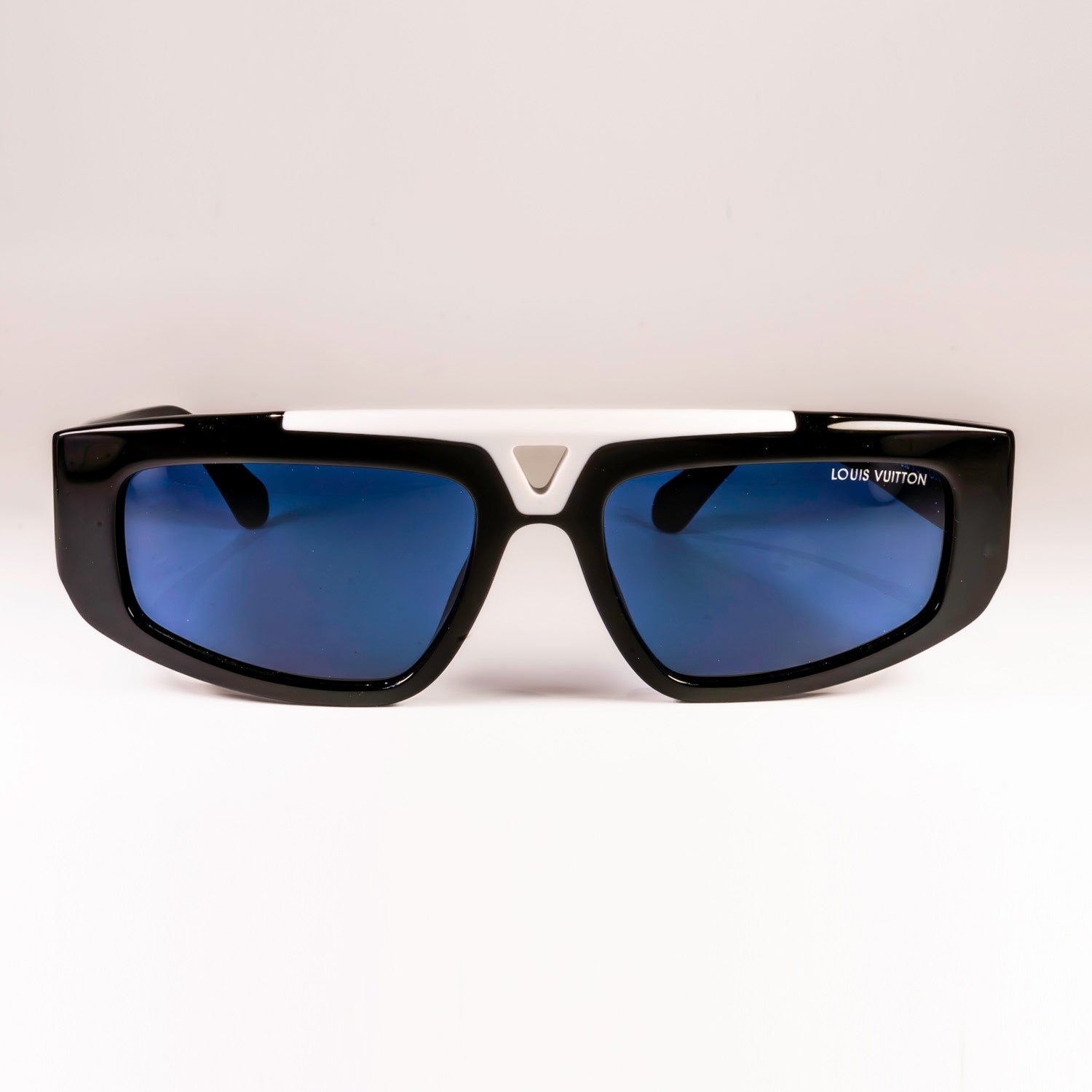 Stylish LV 1.1 Evidence Sport Sunglasses with black acetate frames and grey lenses, featuring white V-shape bridge and engraved Monogram motifs.