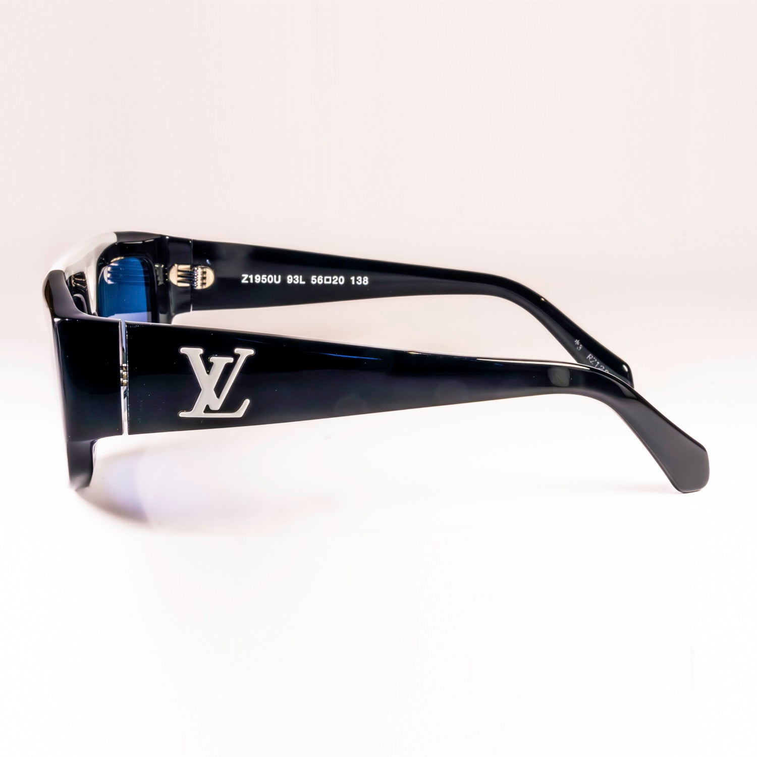 Stylish LV 1.1 Evidence Sport Sunglasses with black acetate frames and grey lenses, featuring white V-shape bridge and engraved Monogram motifs.