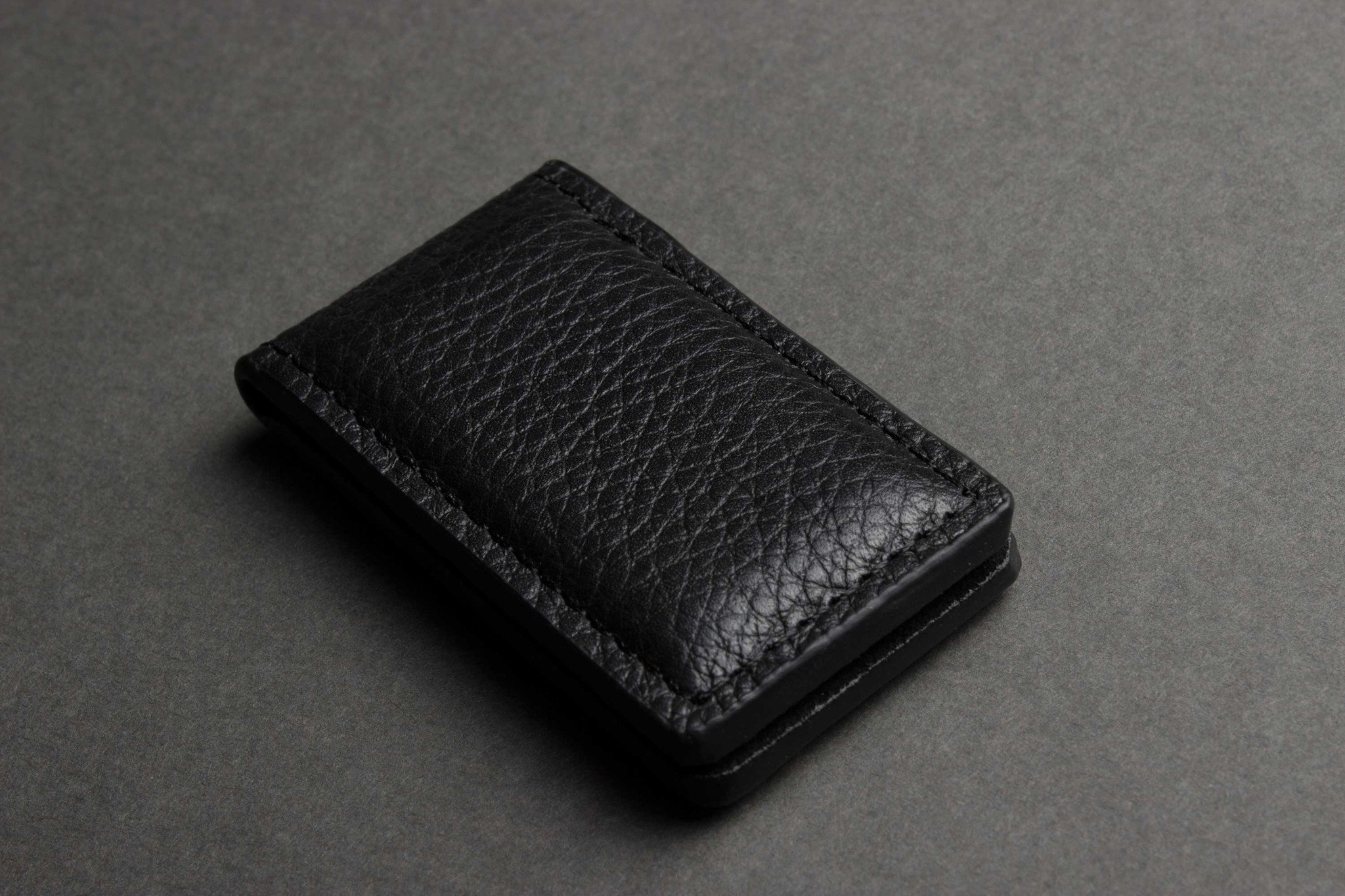 A stylish Magnetic Money Clip made from premium cowhide leather, featuring a compact design and heat burnished details.