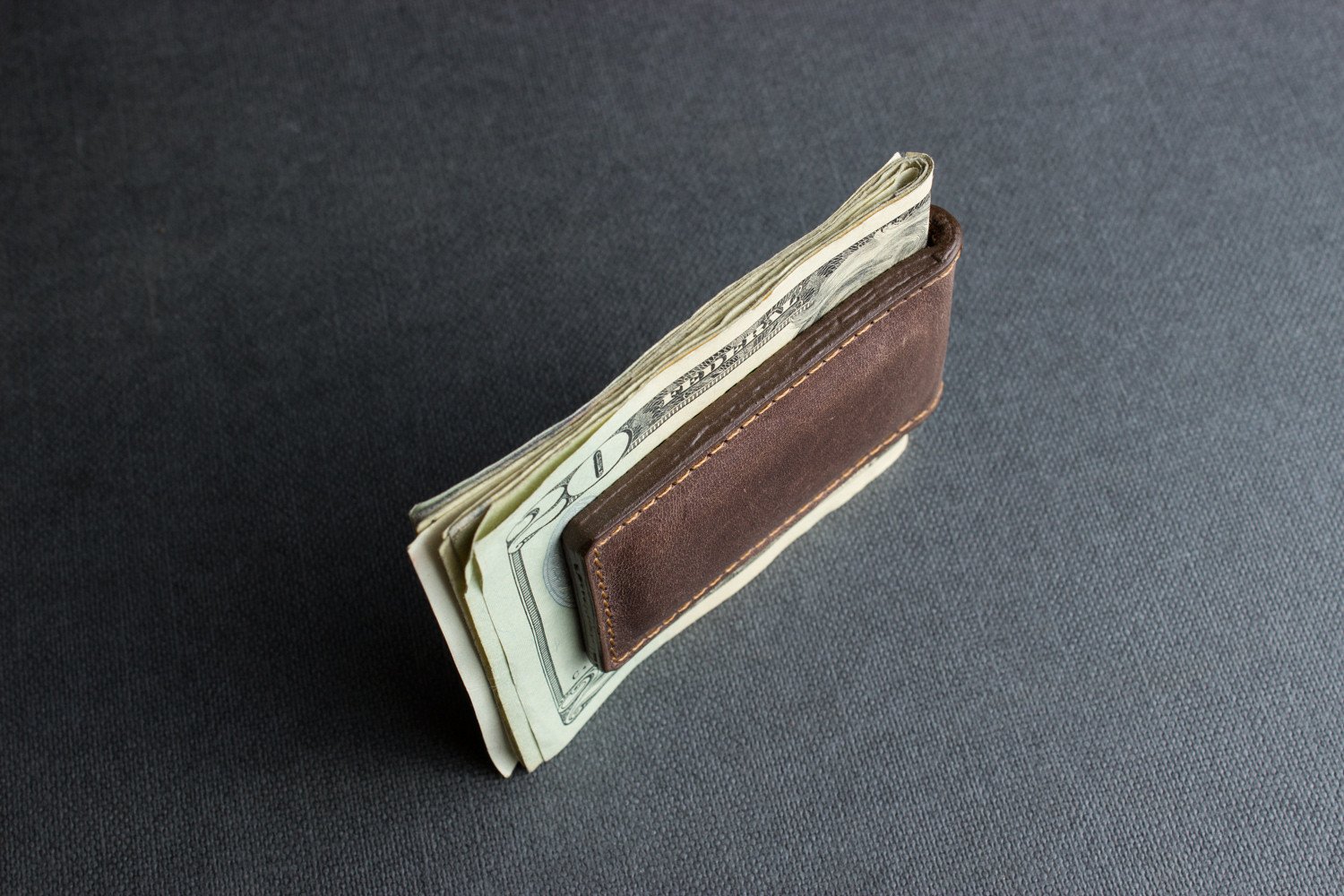 A stylish Magnetic Money Clip made from premium cowhide leather, featuring a compact design and heat burnished details.