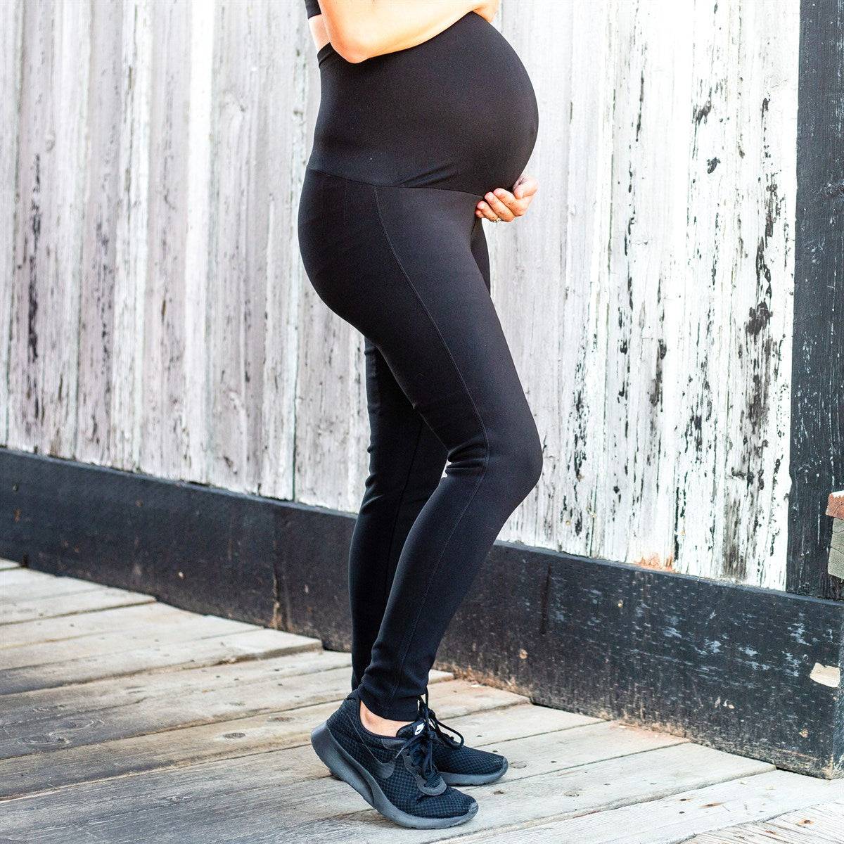 A pair of stylish black maternity leggings featuring a seamless stretch panel and extra tall waistband for support during pregnancy.