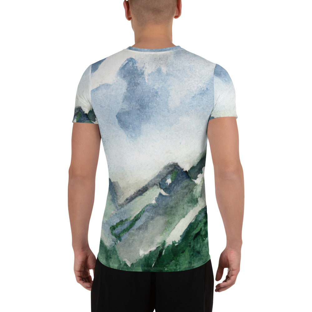 Men's Stretch Fit Athletic Sports T-shirt featuring a green mountainside nature landscape print against a blue sky.