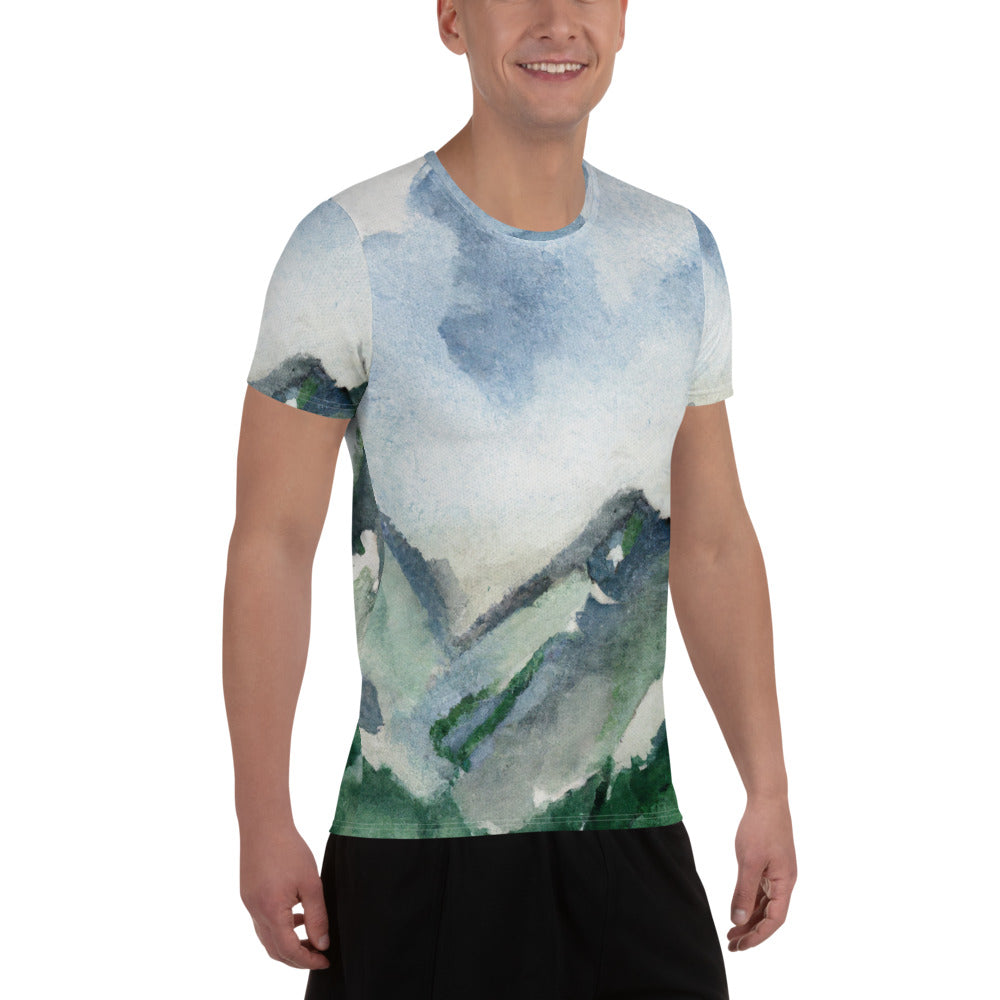 Men's Stretch Fit Athletic Sports T-shirt featuring a green mountainside nature landscape print against a blue sky.