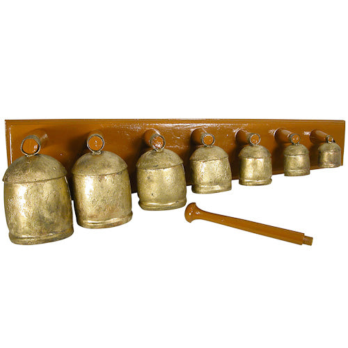 A handcrafted Metal Bell Instrument featuring various sized bells mounted on a wooden board, showcasing intricate metalwork and a wooden mallet.