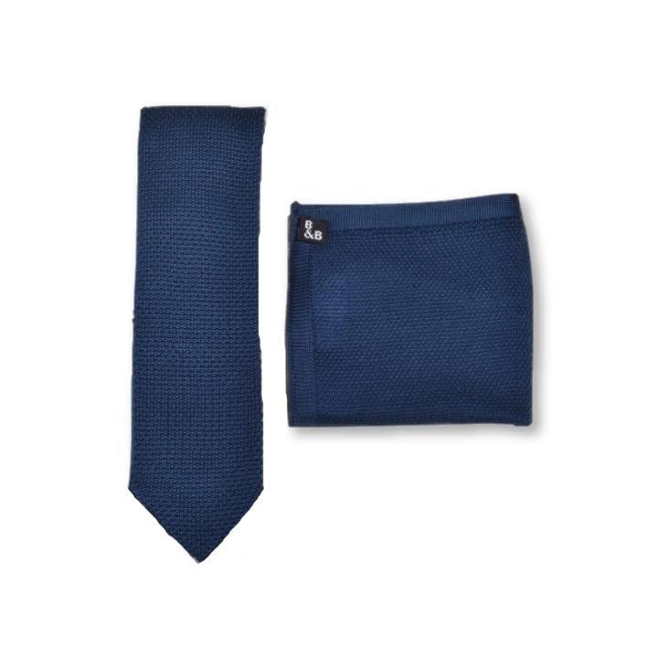 Midnight blue knitted tie and pocket square set displayed elegantly, showcasing the textured fabric and pointed tie end.