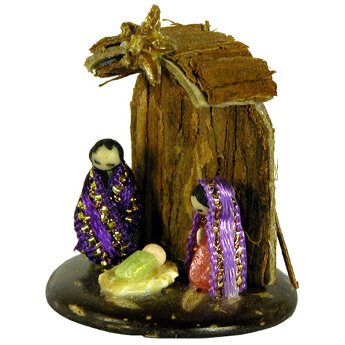 Miniature nativity scene featuring Mary, Joseph, and Baby made from seeds and ribbon, set on a coconut base with Cat's Claw Bark.