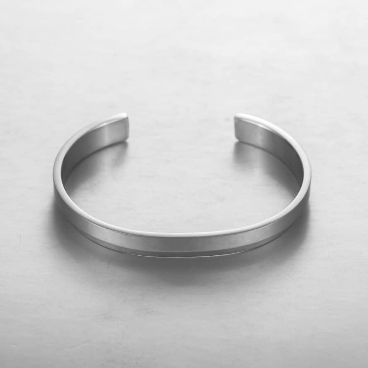 A sleek silver minimalist classic bracelet made from stainless steel, showcasing its elegant design and available sizes.