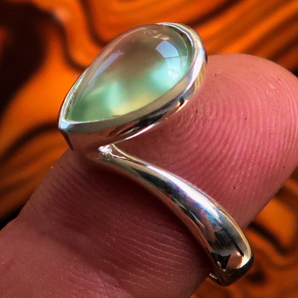 Mirror polished Sterling Silver solitaire ring featuring a pear-shaped green Prehnite stone, hallmarked 925, elegant and modern design.