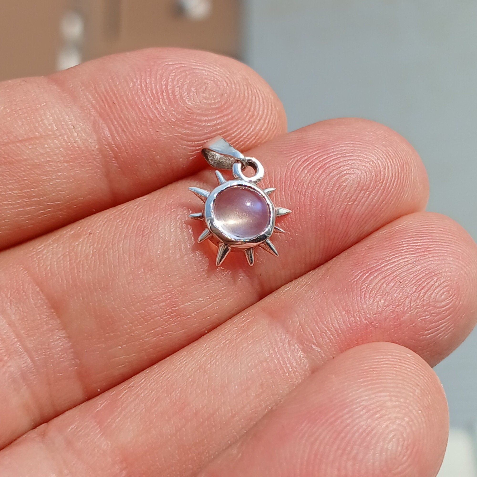 Round Moonstone Pendant set in 925 sterling silver, showcasing its elegant design and shimmering gemstone.