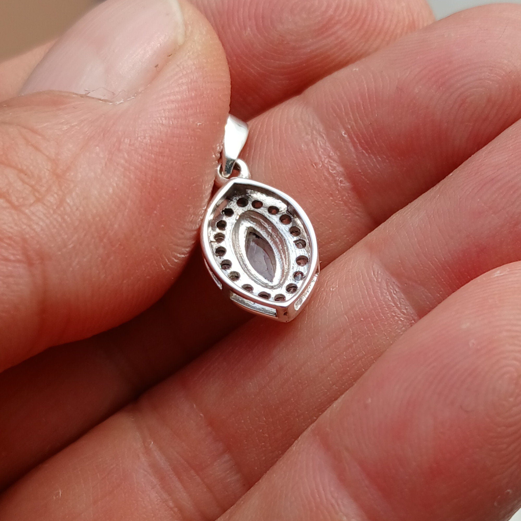 A stunning Moonstone Pendant in sterling silver, featuring a central moonstone surrounded by seven sparkling cubic zirconias.