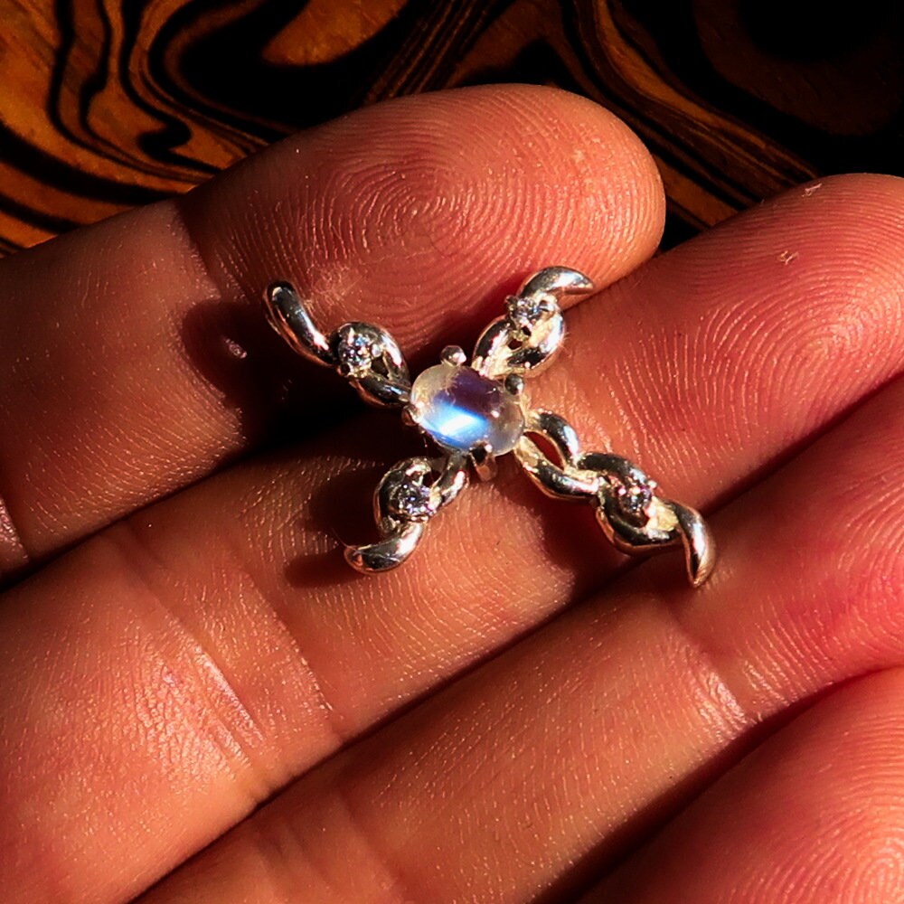 Sterling silver cross pendant featuring a moonstone and cubic zirconia, elegantly designed and hallmarked 925.