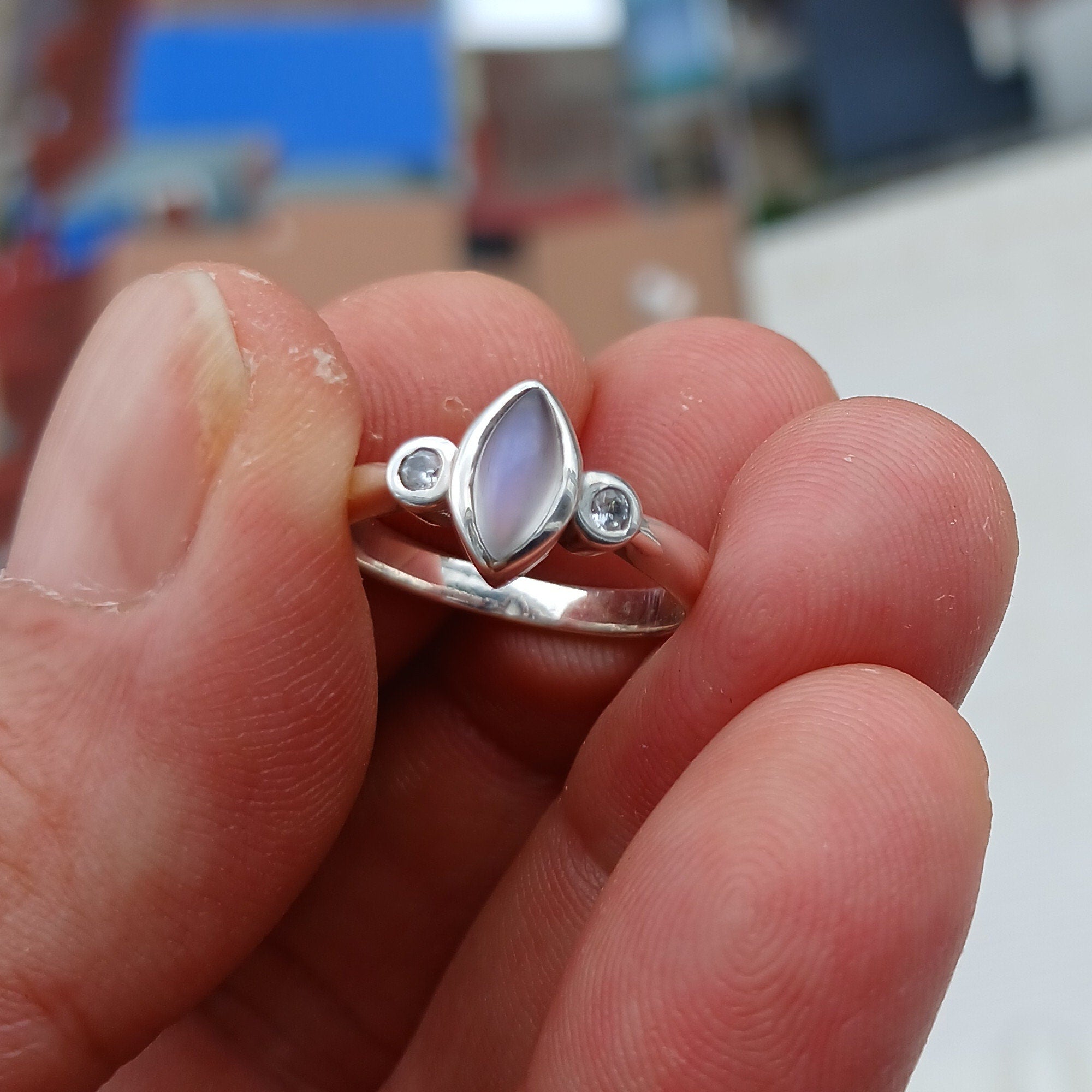 A stunning Moonstone Silver Ring featuring a marquise-shaped Moonstone and two sparkling CZ stones, set in polished Sterling Silver.