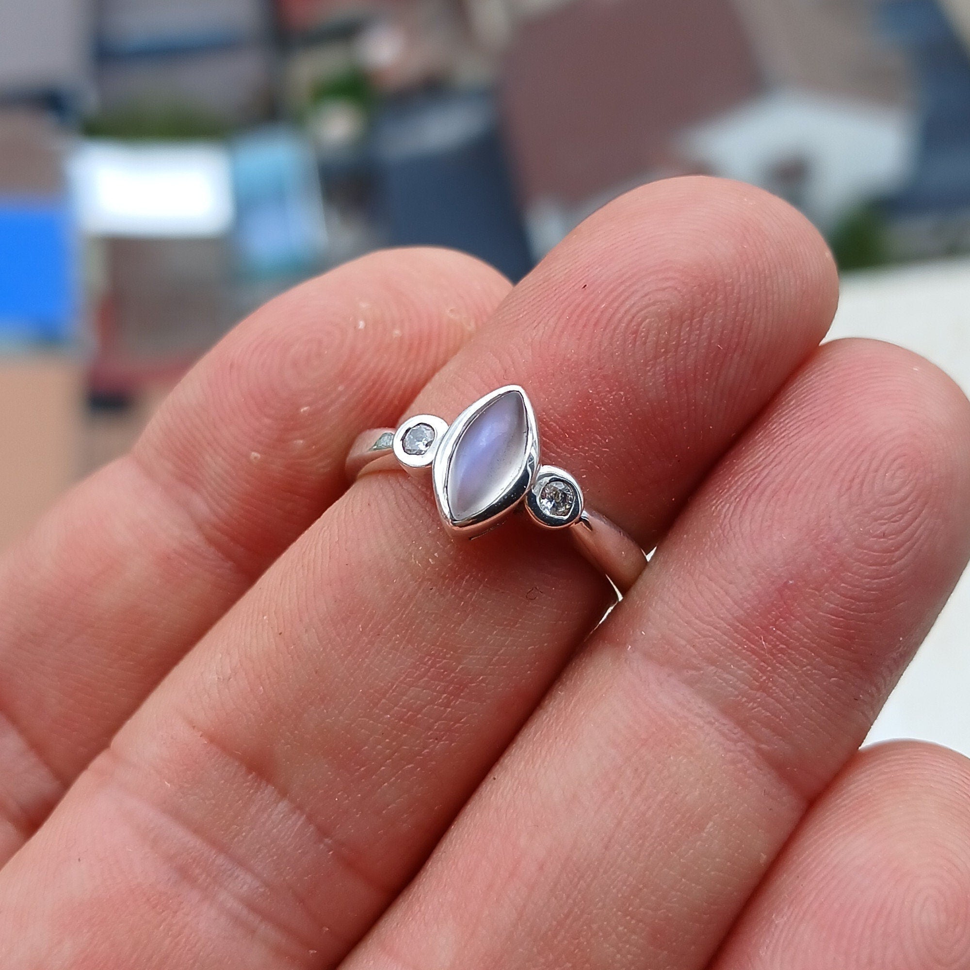 A stunning Moonstone Silver Ring featuring a marquise-shaped Moonstone and two sparkling CZ stones, set in polished Sterling Silver.