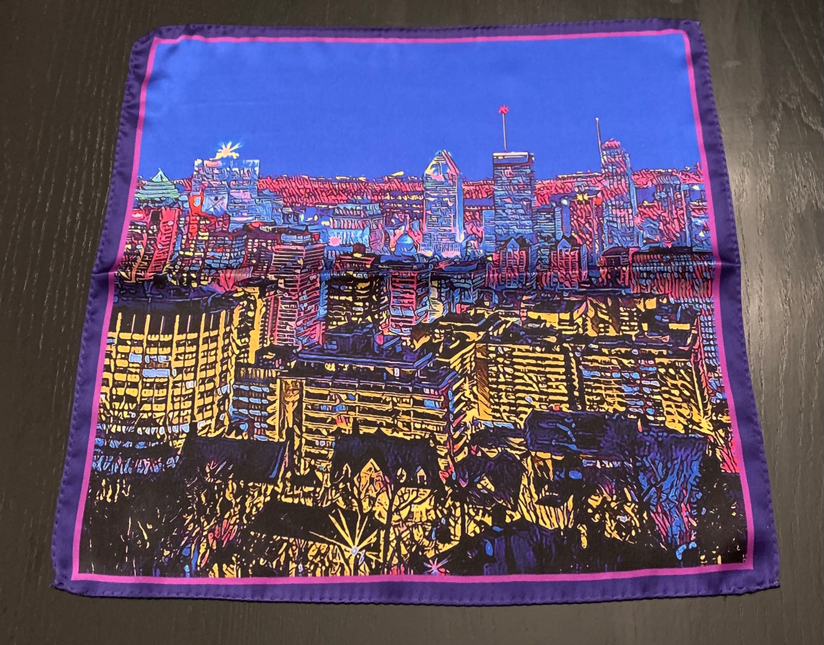 Montreal Skyline Scarf featuring iconic city landmarks in vibrant colors, elegantly draped on a neutral background.