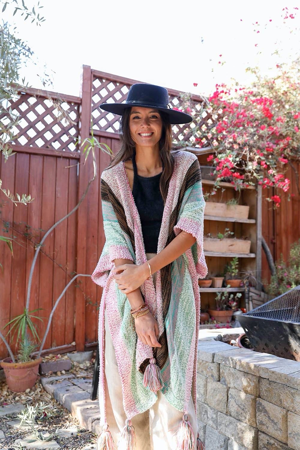 A vibrant multi-color striped poncho with playful tassels, perfect for festivals and casual outings.