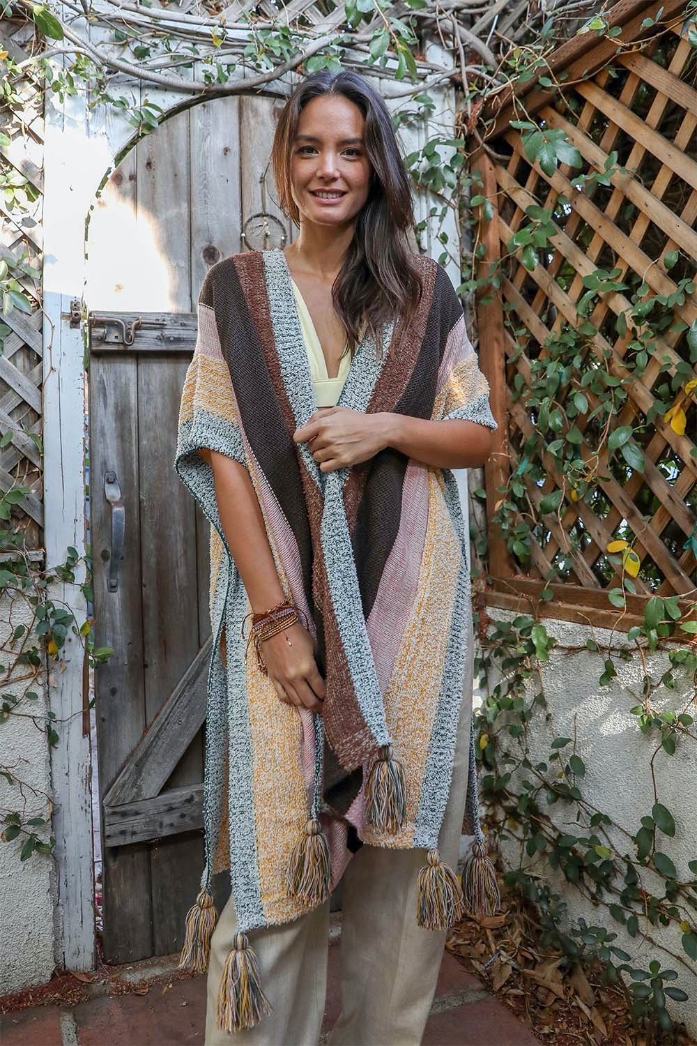 A vibrant multi-color striped poncho with playful tassels, perfect for festivals and casual outings.