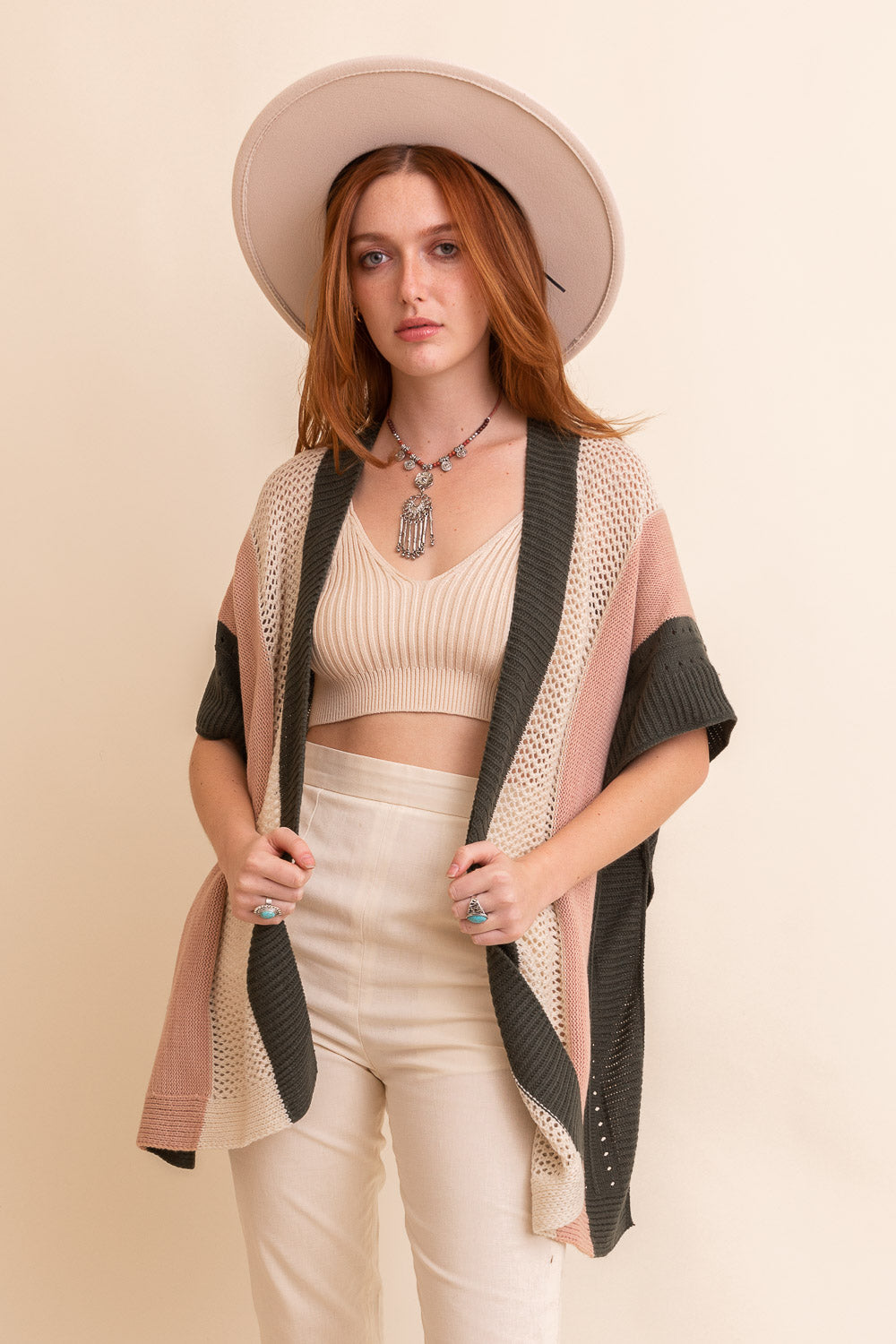 A vibrant multi-colored striped knit poncho draped elegantly, showcasing its cozy fabric and stylish design.