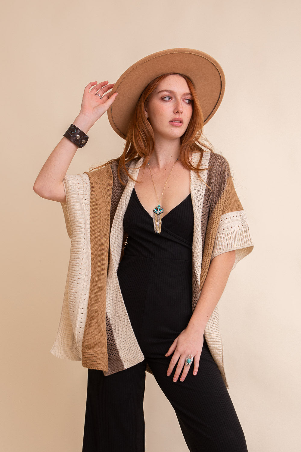 A vibrant multi-colored striped knit poncho draped elegantly, showcasing its cozy fabric and stylish design.