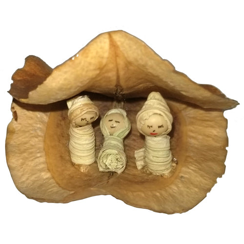 Handmade Nativity scene featuring Mary, Joseph, and baby Jesus on Acacia leaves, crafted from white beans and corn husks.