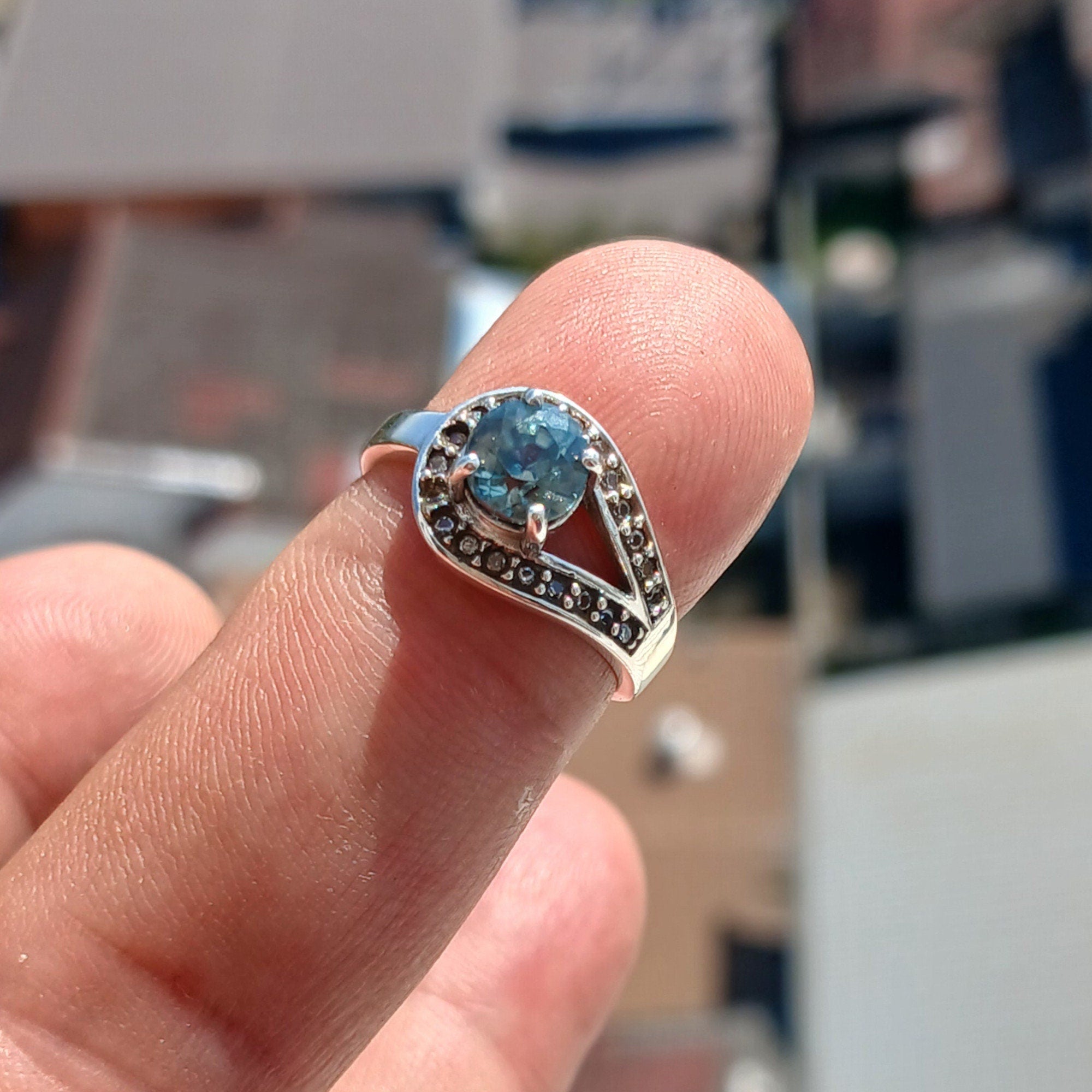 Natural Blue Zircon Ring in sterling silver with CZ accents, showcasing a round cut blue Zircon and elegant design.