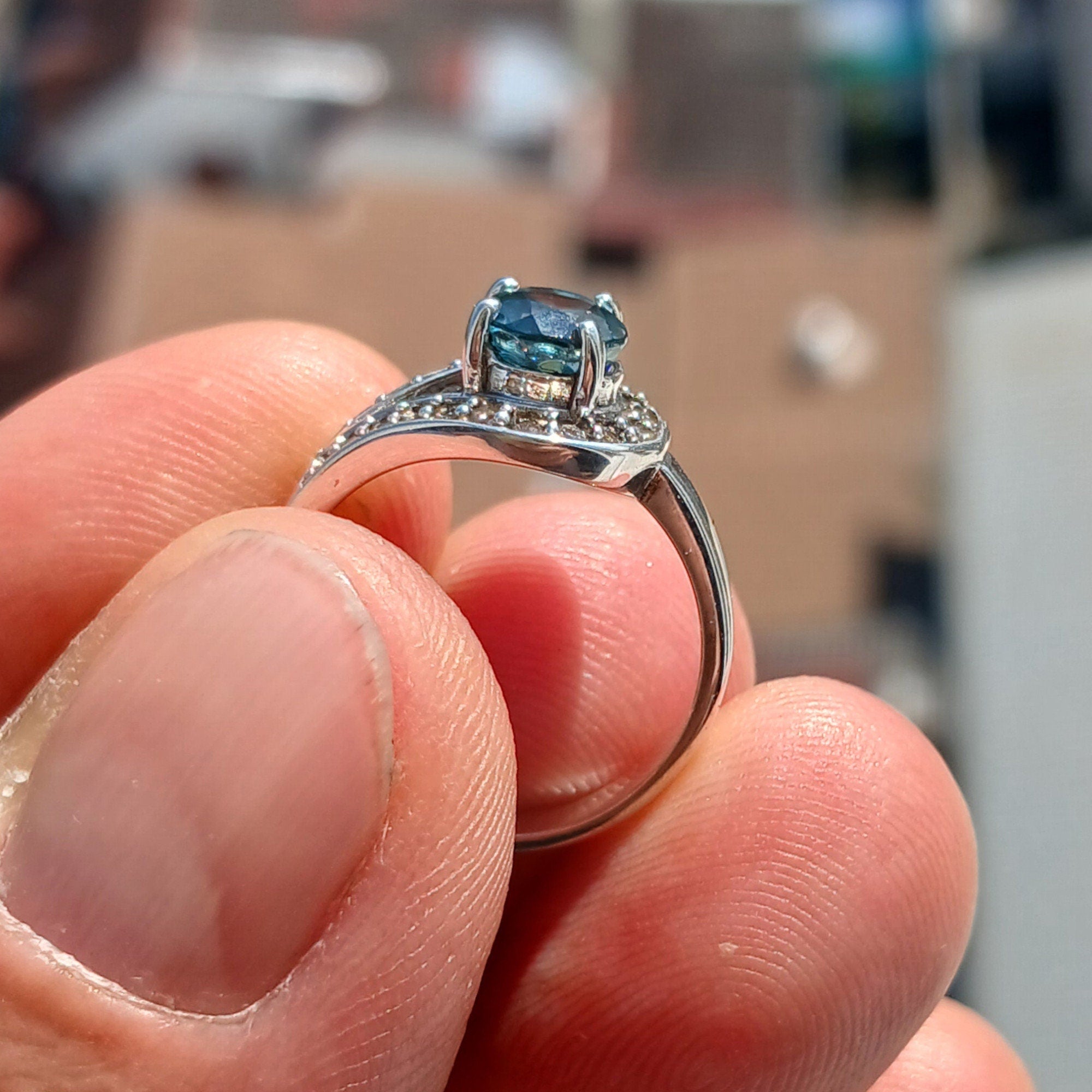 Natural Blue Zircon Ring in sterling silver with CZ accents, showcasing a round cut blue Zircon and elegant design.