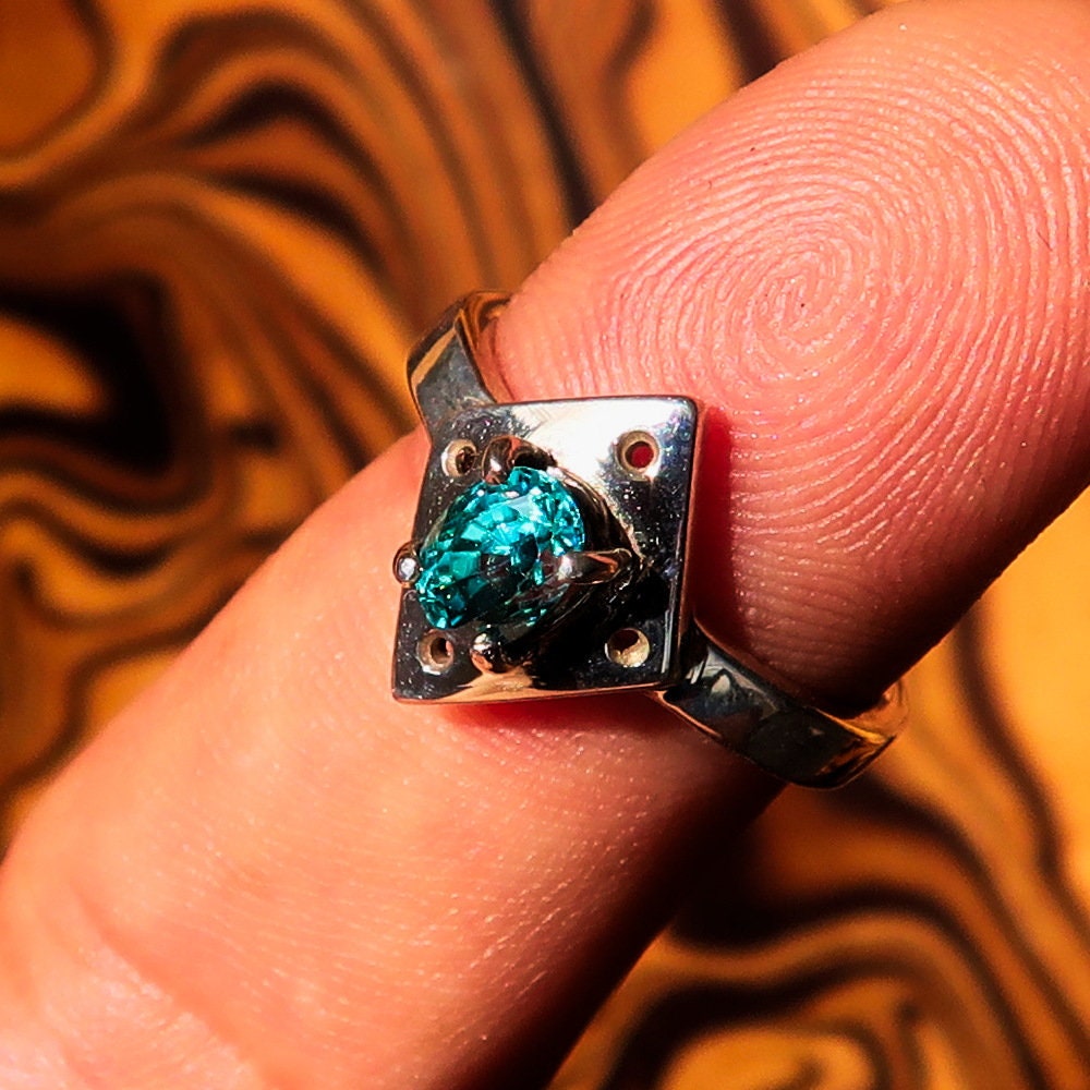 Handmade silver ring featuring a diamond-shaped blue Zircon gemstone, elegantly designed and polished.