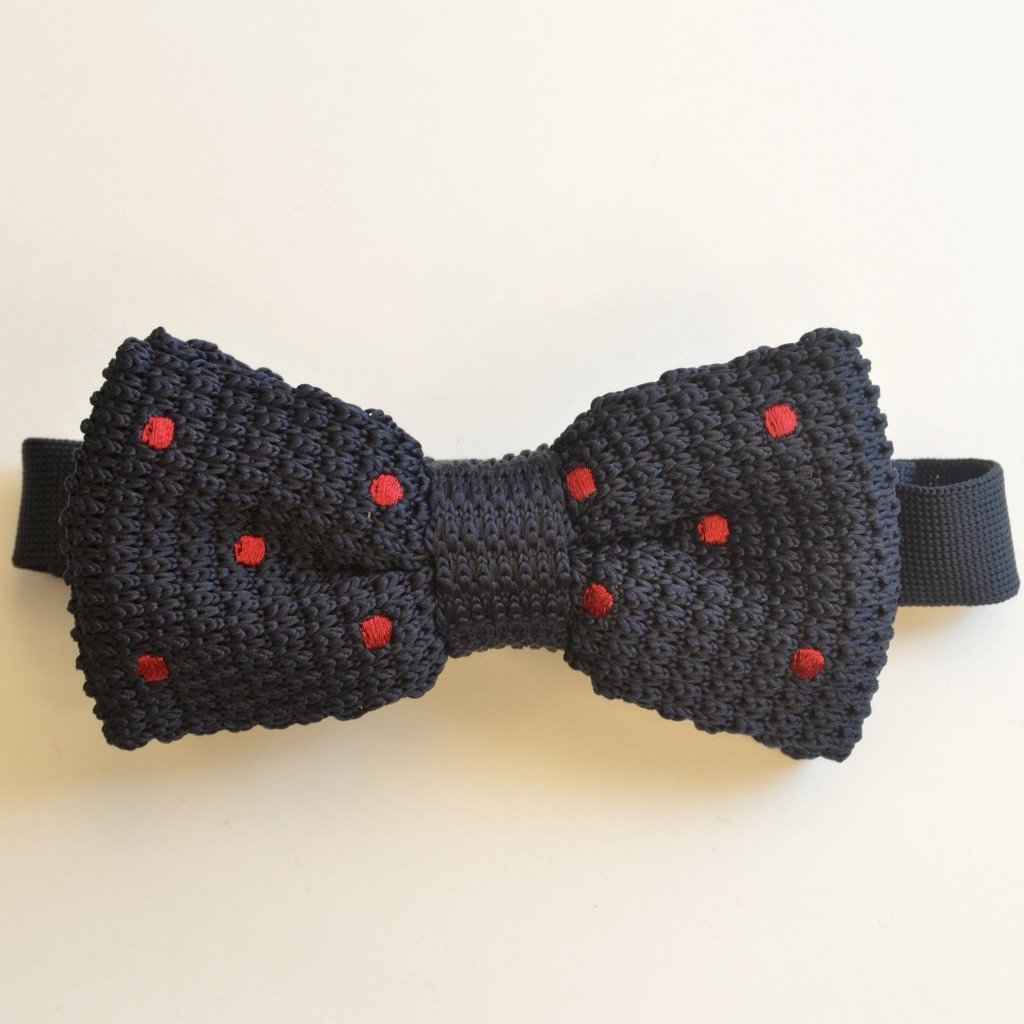 Navy blue and red spotty knitted bow tie, elegantly crafted with a pretied design for easy wear.