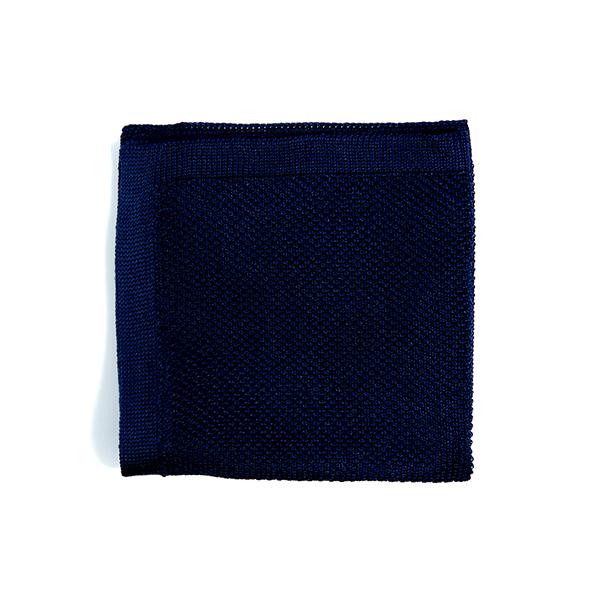 Navy blue knitted pocket square displayed elegantly, showcasing its texture and color.