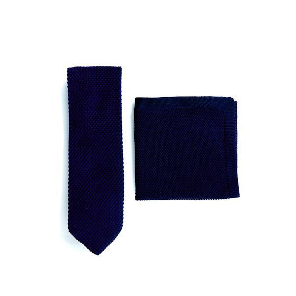 Navy blue knitted tie and pocket square set displayed elegantly, showcasing the texture and color.