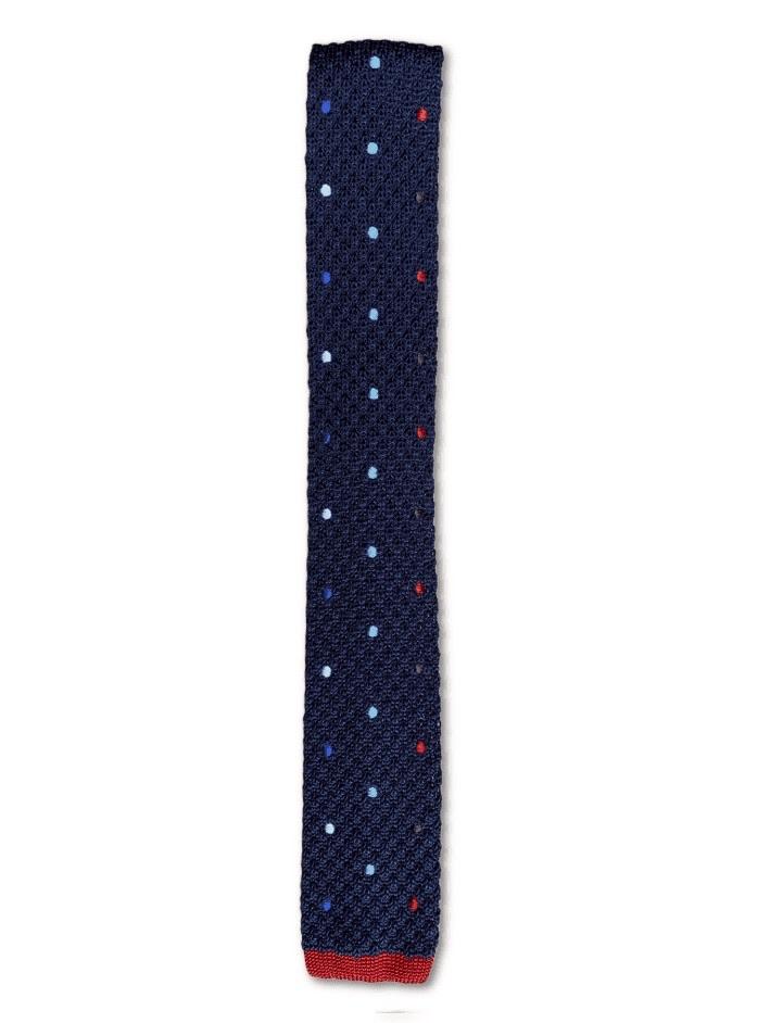 Navy blue knitted tie with baby blue, red, blue, and white polka dots, featuring a square end design.