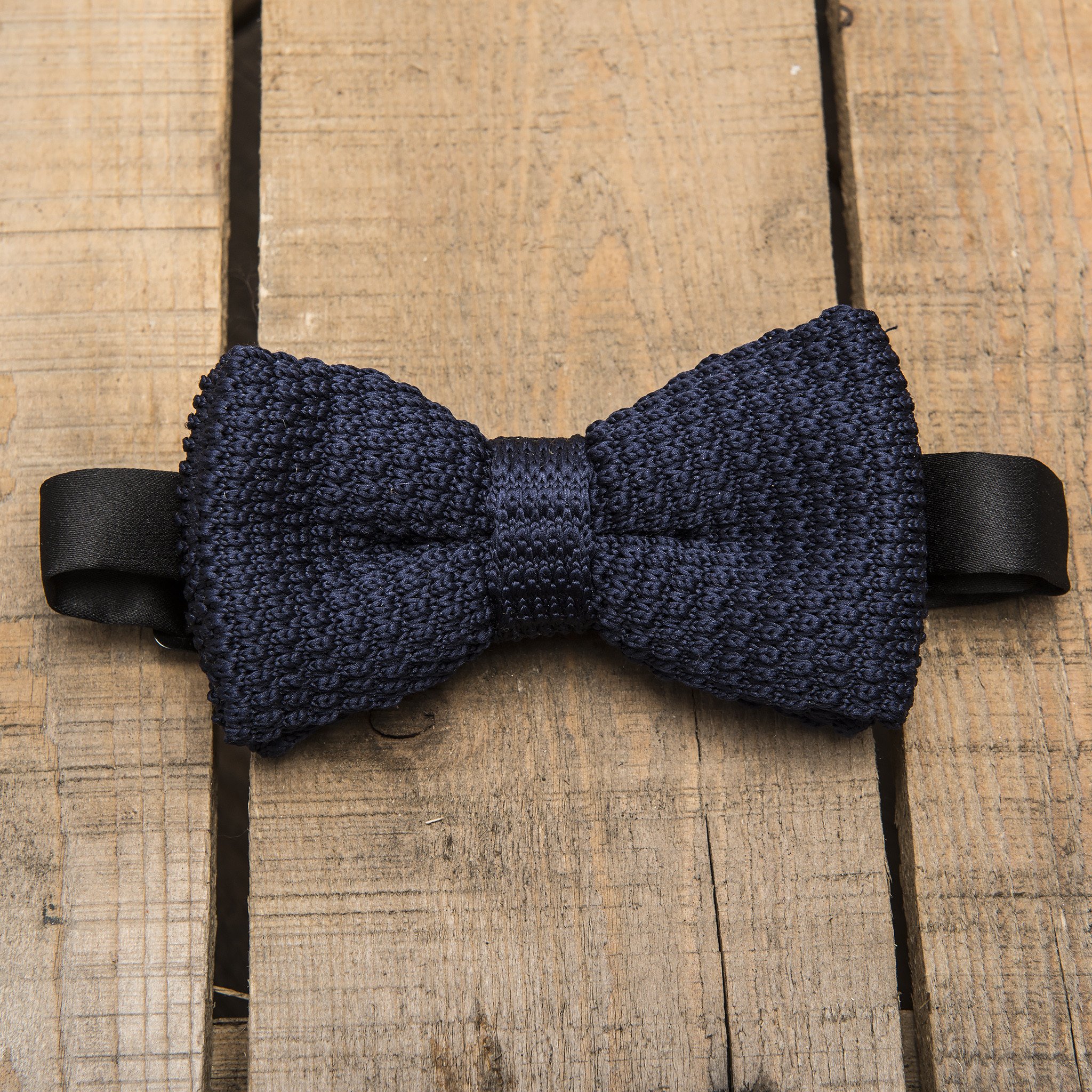 Navy blue waffle knitted bow tie with adjustable strap, showcasing its unique texture and elegant design.