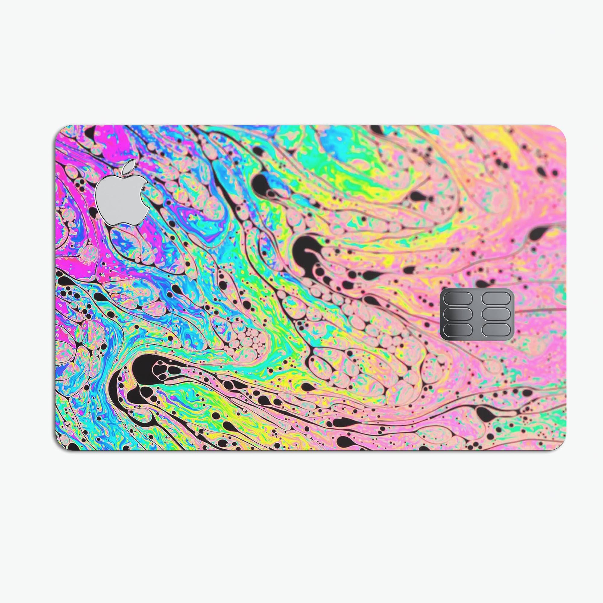 Neon Color Fusion decal with black splatters applied on an Apple Card, showcasing vibrant colors and stylish design.