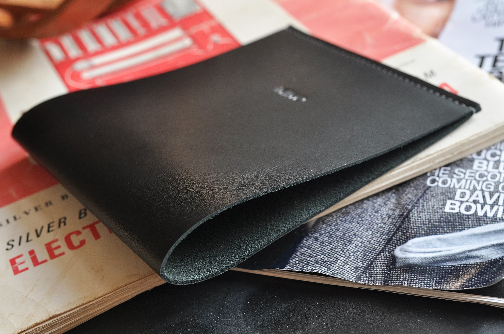 Elegant leather newspaper holder crafted from drum-dyed leather, perfect for organizing magazines and documents.