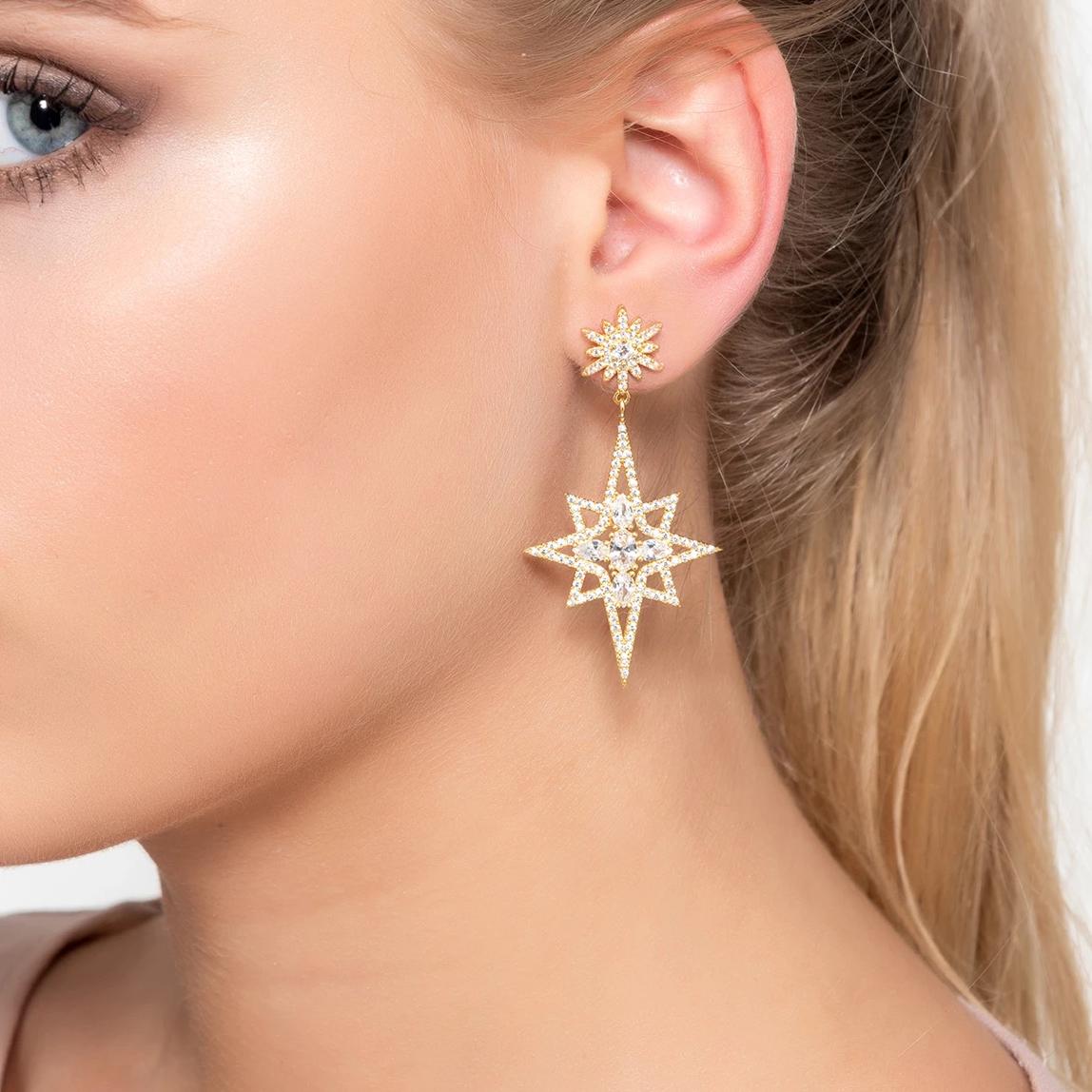 Northern Star Burst Drop Earrings in silver, featuring a large star burst design with sparkling cubic zirconia, elegantly hanging from a stud.