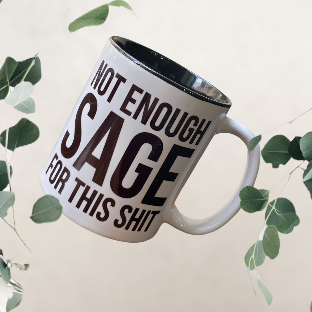 A humorous black and white ceramic mug with the phrase 'Not Enough Sage For This Shit' printed on both sides, perfect for coffee or tea.