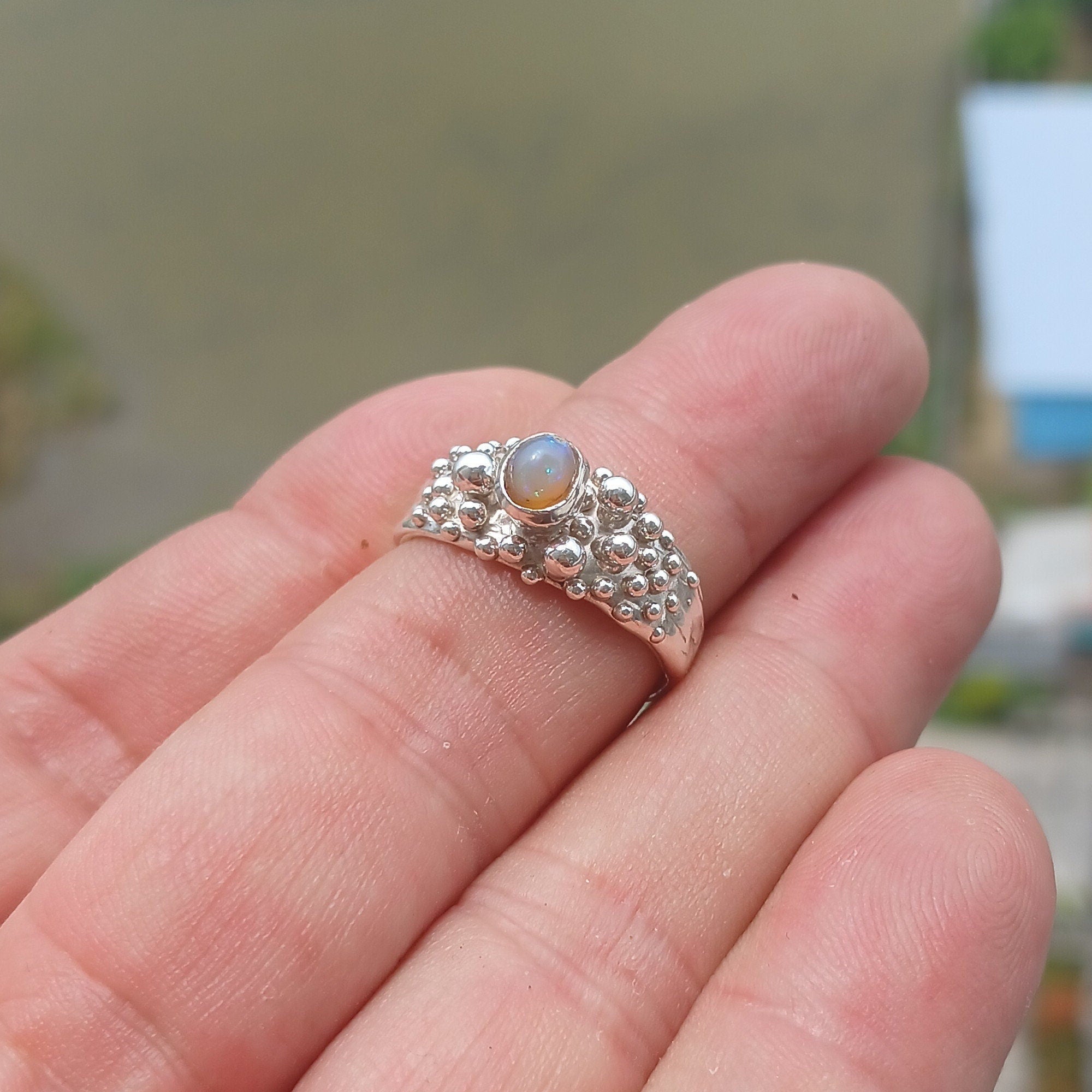 A beautiful handcrafted sterling silver Opal Ring featuring an oval-shaped opal with vibrant colors, elegantly polished for a sophisticated look.