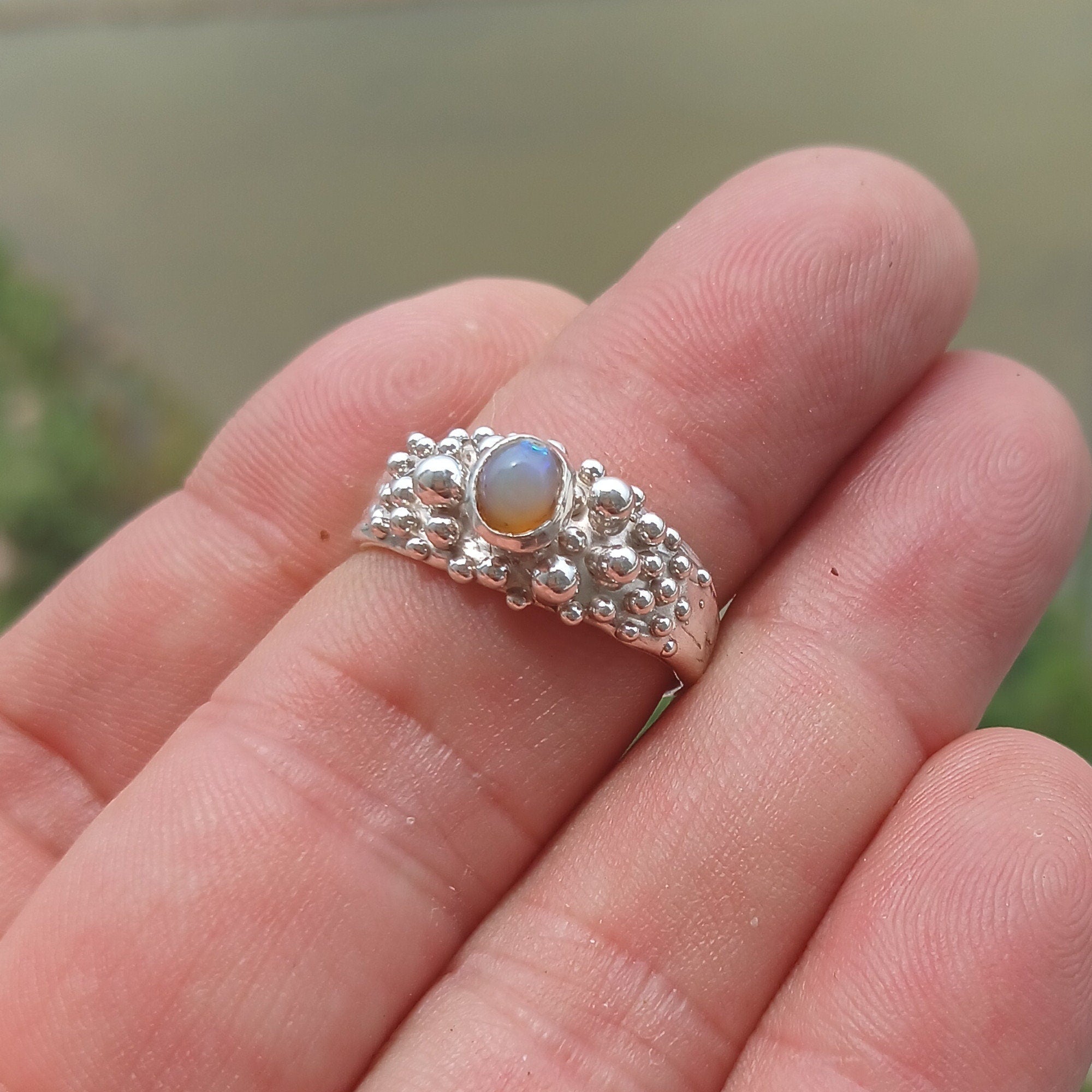 A beautiful handcrafted sterling silver Opal Ring featuring an oval-shaped opal with vibrant colors, elegantly polished for a sophisticated look.